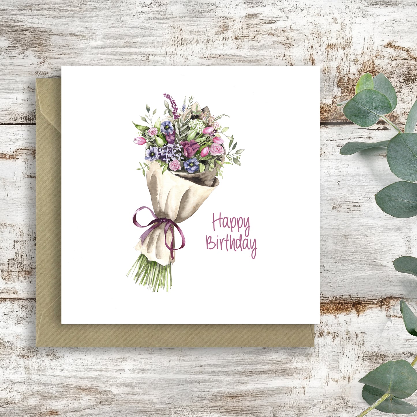Handcrafted happy birthday card with watercolor bouquet illustration on rustic wooden background