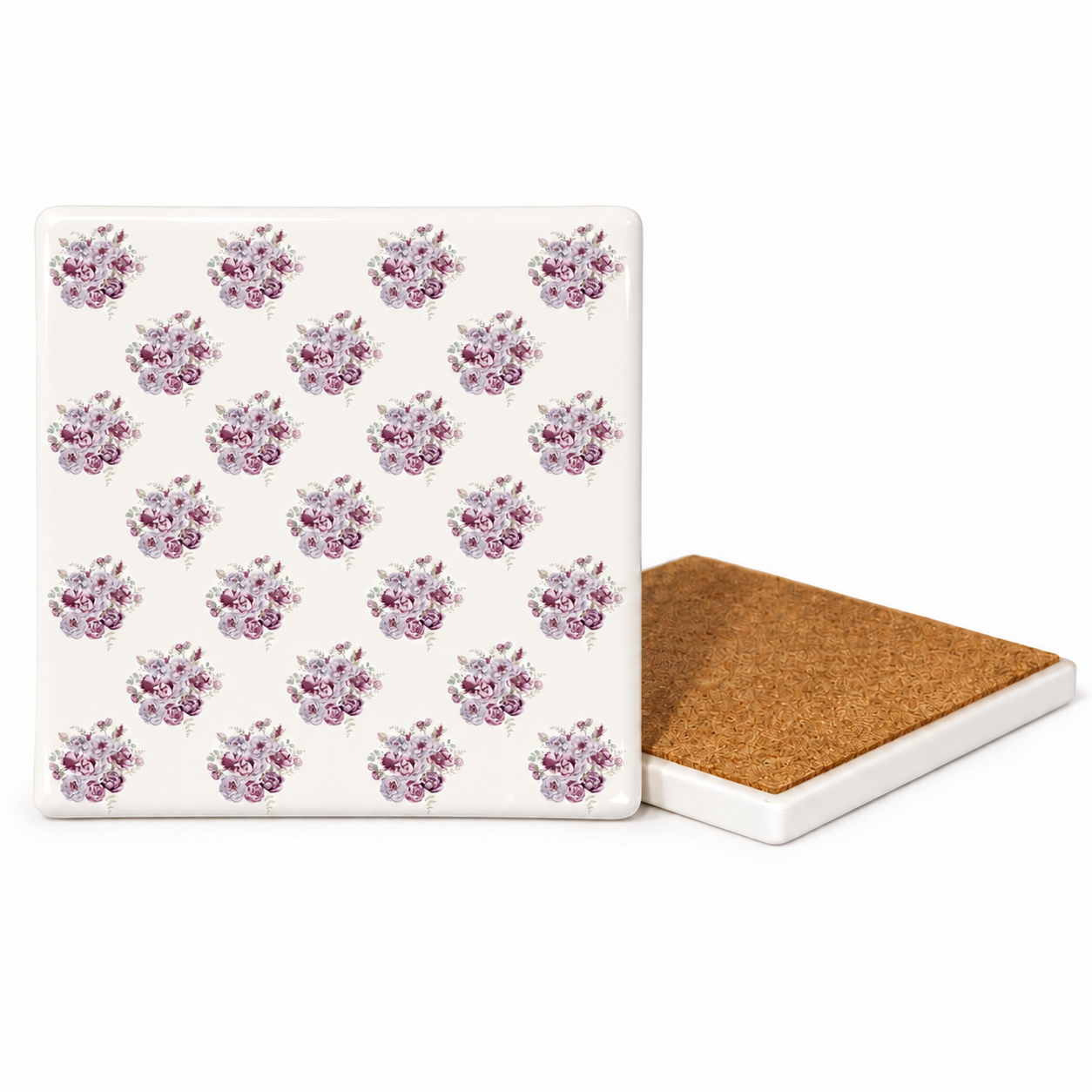 A square ceramic coaster with a repeating purple and pink floral pattern on an off-white background, shown next to another coaster turned to show its brown cork backing, on a clean white background.
