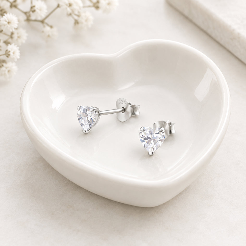 Heart-shaped crystal stud earrings on a white background